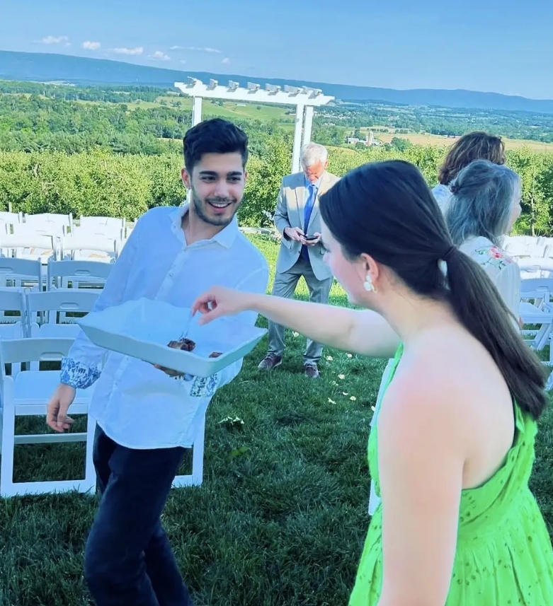 Otto server passing appetizers at an outdoor wedding