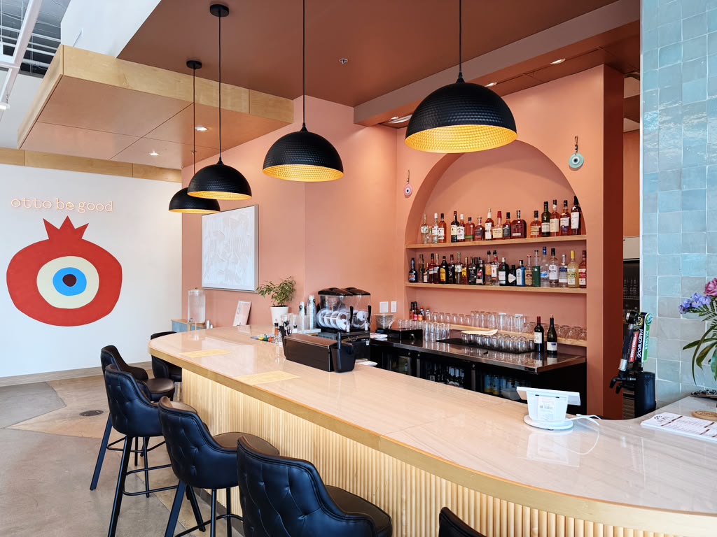 Full-service bar at Otto Richmond beneath the Otto pomegranate mural